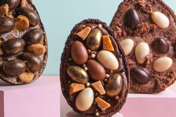 Three Easter eggs halves filled with small eggs and chocolate filling standing upright